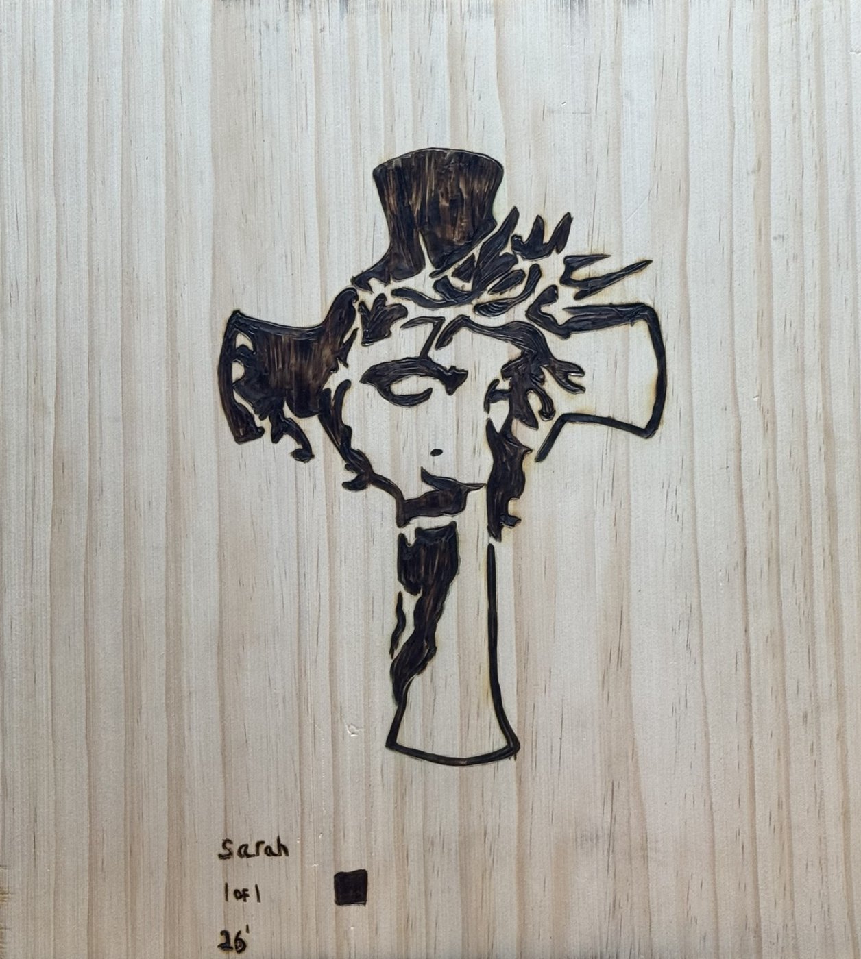 Amen — the flip side: a second Jesus burned into a cross on the back of the board, signed Sarah, 1 of 1, '26, with her black square
